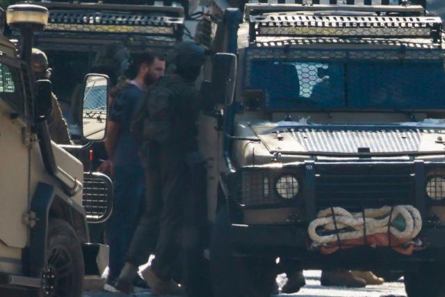 EDITORS NOTE: Graphic content / Israeli soldiers detain a man as they surround the Nablus Specialized Hospital where they allegedly arrested a wounded man and his brother from inside the hospital in Nablus, in the Israeli-occupied West Bank on July 24, 2026. Israeli Prime Minister Benjamin Netanyahu vowed a forceful response on July 24 after a clash in the West Bank killed an Israeli and four Palestinians, while the military announced preparations for a new operation in the occupied area. (Photo by Jaafar ASHTIYEH / AFP)