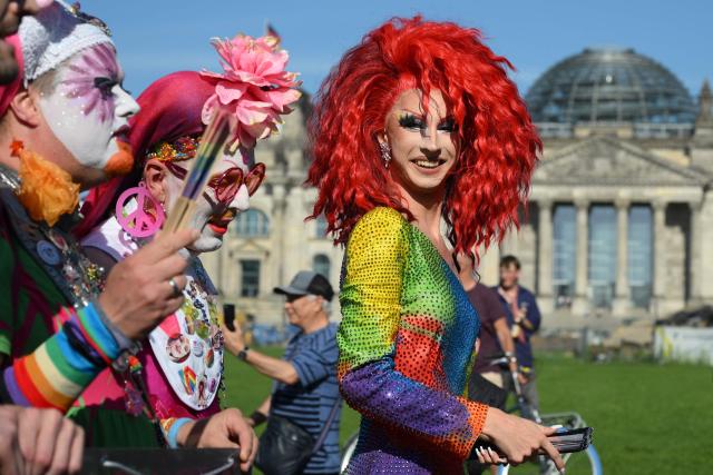 Participants pass by the Reichstag building in Berlin, which houses Germany's Bundestag lower house of parliament, during the start of the Drag Queen March on July 24, 2026. Ahead of the Christopher Street Day (CSD) parade, Berlin hosts its first-ever Drag March bringing a tradition known from New York to Berlin. (Photo by RALF HIRSCHBERGER / AFP)