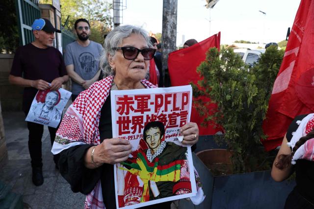 A woman holds a poster of Japanese militant Kozo Okamoto, also known as “Ahmed al-Yabani” (Ahmed the Japanese) as she and members and supporters of the Popular Front for the Liberation of Palestine (PFLP), joined by Lebanese and Palestinian participants, attend his funeral procession in Beirut on July 24, 2026. The procession set off from Al-Khashoggi Mosque before burial at the Martyrs’ Cemetery of the Palestinian Revolution. Okamoto, was part of a three-man commando from the Japanese Red Army that killed 26 people, eight Israelis, a Canadian, and 17 Christian pilgrims from Puerto Rico on May 30, 1972 at Lod airport -- now known as Ben Gurion -- near Tel Aviv in an attack planned by the PFLP. Okamoto died on July 23, 2026 aged 78, the group said. (Photo by Anwar AMRO / AFP)