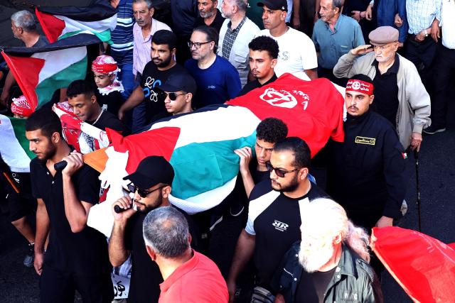 A man salutes as he walks behind the body of Japanese militant Kozo Okamoto, also known as “Ahmed al-Yabani” (Ahmed the Japanese), as members and supporters of the Popular Front for the Liberation of Palestine (PFLP), joined by Lebanon's and Palestine's participants, take part in his funeral procession in Beirut on July 24, 2026. The procession set off from Al-Khashoggi Mosque before burial at the Martyrs’ Cemetery of the Palestinian Revolution. Okamoto, was part of a three-man commando from the Japanese Red Army that killed 26 people, eight Israelis, a Canadian, and 17 Christian pilgrims from Puerto Rico on May 30, 1972 at Lod airport -- now known as Ben Gurion -- near Tel Aviv in an attack planned by the PFLP. Okamoto died on July 23, 2026 aged 78, the group said. (Photo by Anwar AMRO / AFP)