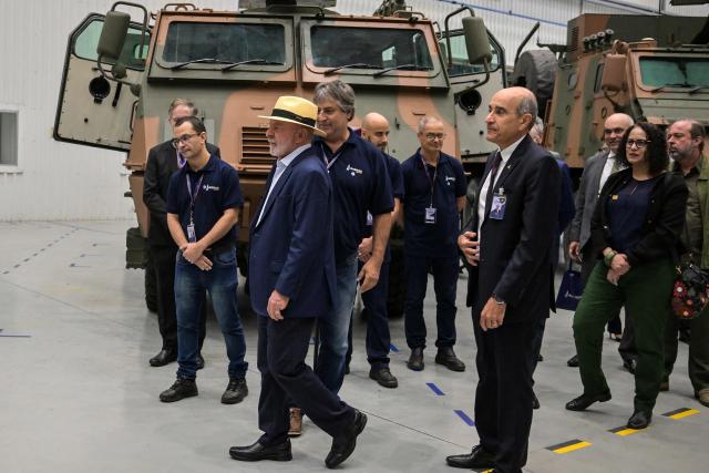 Brazil's President Luiz Inacio Lula da Silva (C-L) walks followed by the CEO of Brazilian defense and aerospace company Avibras Aeroco, Sami Hassuani (C-R), during a visit to the Avibras Aeroco headquarters, in Jacarei, some 90 km from Sao Paulo, Brazil, on July 24, 2026. (Photo by Nelson ALMEIDA / AFP)