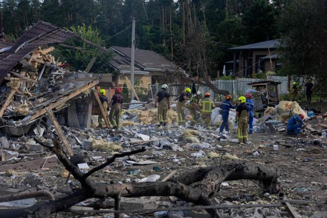 TOPSHOT - Rescuers work in the rubble of private houses at the site of a Russian missile strike at an undisclosed location in Kyiv region on July 24, 2026, amid the Russian invasion of Ukraine. (Photo by Tetiana DZHAFAROVA / AFP)