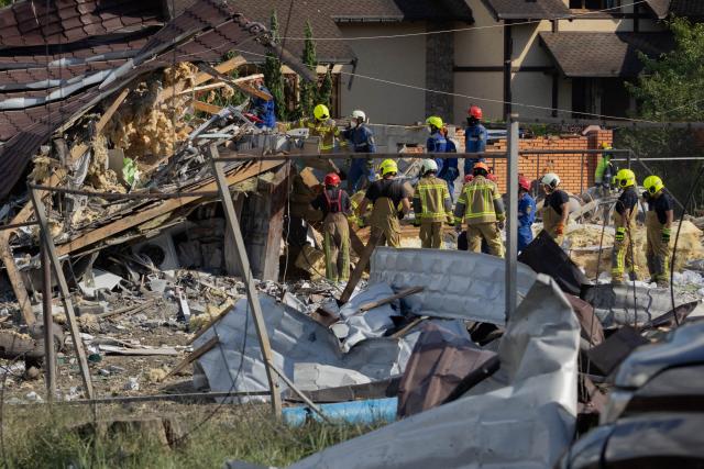 Rescuers work near damaged private houses at the site of a Russian missile strikes at an undisclosed location in Kyiv region on July 24, 2026, amid the Russian invasion of Ukraine. (Photo by Tetiana DZHAFAROVA / AFP)