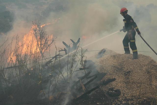 A firefighter waters rubbles while battling a wildfire in Cebreros area, near Avila, 80 kms west of Madrid on July 24, 2026. The worst wildfires in the Madrid region's history rage west of the Spanish capital, forcing authorities to evacuate or order around 40,000 people to remain indoors. (Photo by Cesar MANSO / AFP)