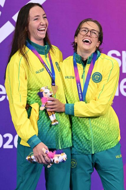 Australia's Lani Pallister (L) and Australia's Jenna Forrester celebrate during the Women's 400m Freestyle Medal Ceremony at the swimming event at the Tollcross International Swimming Centre in Glasgow, on day one of the Commonwealth Games in Glasgow, Scotland, on July 24, 2026. (Photo by Oli SCARFF / AFP)