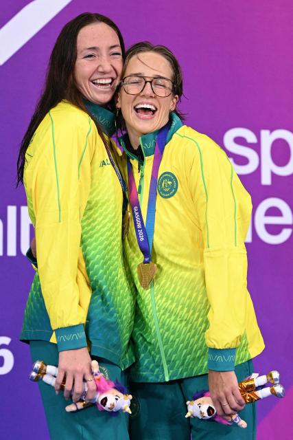 Australia's Lani Pallister (L) and Australia's Jenna Forrester celebrate during the Women's 400m Freestyle Medal Ceremony at the swimming event at the Tollcross International Swimming Centre in Glasgow, on day one of the Commonwealth Games in Glasgow, Scotland, on July 24, 2026. (Photo by Oli SCARFF / AFP)