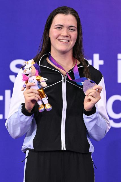Bronze medallist New Zealand's Erika Fairweather celebrates during the Women's 400m Freestyle Medal Ceremony at the swimming event at the Tollcross International Swimming Centre in Glasgow, on day one of the Commonwealth Games in Glasgow, Scotland, on July 24, 2026. (Photo by Oli SCARFF / AFP)