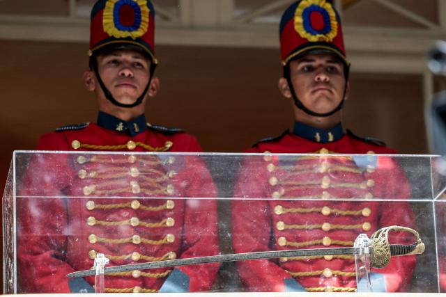 Members of the presidential guard stang guard beside the ceremonial sword of Simon Bolivar, the 19th-century South American independence leader, at the Quinta de Bolivar museum in Bogota on July 24, 2026, as the historic artifact is returned to its traditional home. (Photo by Jose VARGAS / AFP)