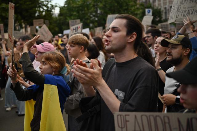 Attendees hold placards and chant slogans during a demonstration to protest against Ukraine's President's decision to dismiss Ukraine's former Defence Minister, in Kyiv on July 24, 2026, amid the Russian invasion of Ukraine. Ukraine's ex-defence minister -- whose ousting trigged a week of protests and forced out the country's commander-in-chief -- said on July 23, 2026, he was rejecting offers by Ukraine's President for a new role. (Photo by Genya SAVILOV / AFP)