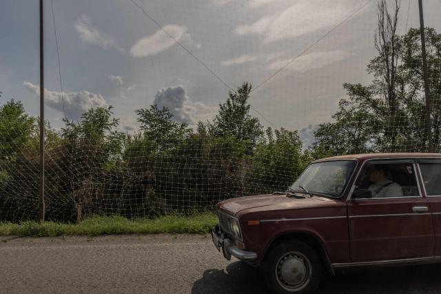 A car drives along a road covered with anti-drone nets in the eastern Kharkiv region on July 23, 2026, amid the Russian invasion of Ukraine. (Photo by Roman PILIPEY / AFP)