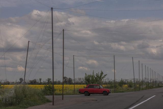 A car drives on a road covered with anti-drone nets in the eastern Kharkiv region on July 23, 2026, amid the Russian invasion of Ukraine. (Photo by Roman PILIPEY / AFP)