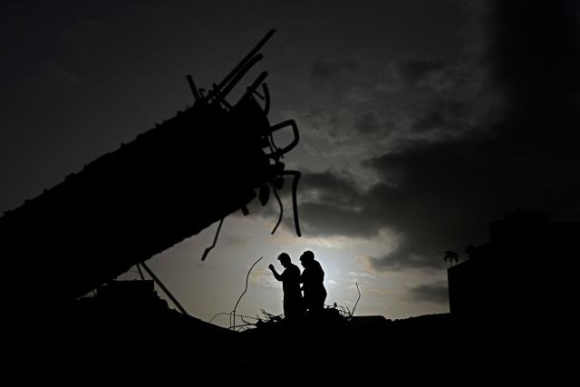 Volunteers take part in the search for bodies amid the rubble of an Obras del Poder Popular (OPP) building in Caraballeda, Venezuela, on July 24, 2026, one month after an earthquake struck the area. Recovering from the earthquakes in Venezuela will take years, the Red Cross said on July 24, one month on from the June 24 disaster that killed more than 5,000 people. (Photo by Federico PARRA / AFP)