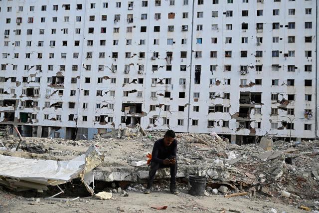 A man rests amid the rubble of a collapsed building during a mass in Caraballeda, Venezuela, on July 24, 2026, one month after an earthquake struck the area. Recovering from the earthquakes in Venezuela will take years, the Red Cross said on July 24, one month on from the June 24 disaster that killed more than 5,000 people. (Photo by Federico PARRA / AFP)