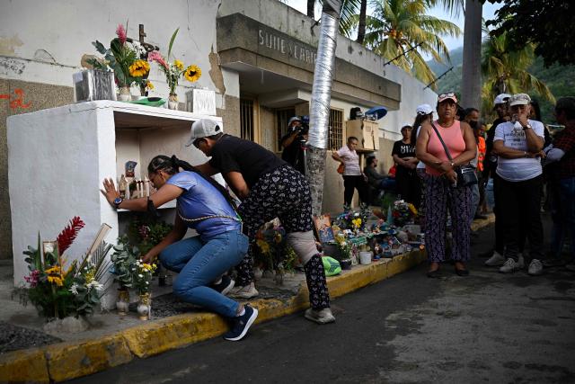 Relatives visit an altar for the victims in front of a collapsed Obras del Poder Popular (OPP) building in Caraballeda, Venezuela, on July 24, 2026, one month after an earthquake struck the area. Recovering from the earthquakes in Venezuela will take years, the Red Cross said on July 24, one month on from the June 24 disaster that killed more than 5,000 people. (Photo by Federico PARRA / AFP)