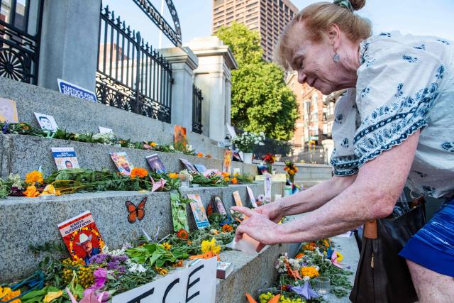 People lay flowers and candles at a memorial during a 24-hour vigil honoring Johan Sebastian Duran Guerrero, a 25-year-old Colombian national, and Lorenzo Salgado Araujo, a 52-year-old Mexican construction worker, who were fatally shot during US Immigration and Customs Enforcement (ICE) operations at the State House in Boston, on July 24, 2026. (Photo by JOSEPH PREZIOSO / AFP)