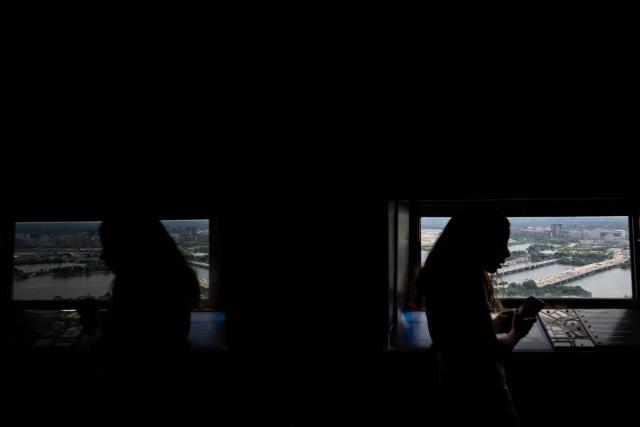 A visitor looks out to the south of the Washington Monument observation deck, towards East Potomac Park, Reagan National Airport and Arlington, Virginia, in Washington, DC on July 24, 2026. (Photo by Kent Nishimura / AFP)