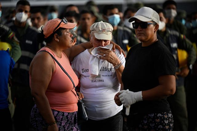 Relatives cry during a mass for the victims in Caraballeda, Venezuela, on July 24, 2026, one month after an earthquake struck the area. Recovering from the earthquakes in Venezuela will take years, the Red Cross said on July 24, one month on from the June 24 disaster that killed more than 5,000 people. (Photo by Federico PARRA / AFP)