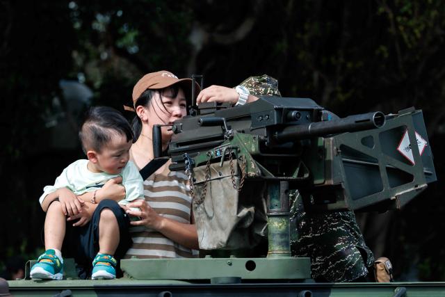 A Taiwanese soldier shows a visitor how to operate an MK19 Mod 3 40mm automatic grenade launcher mounted on a military vehicle during an open day at the National Defence University’s Fuxinggang campus in Taipei on July 25, 2026. (Photo by CHENG Yu-chen / AFP)