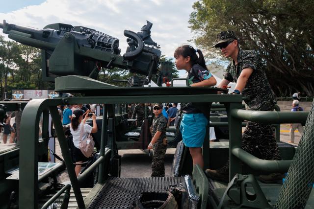 A Taiwanese soldier shows a visitor how to operate a domestically produced T75 20mm auto cannon mounted on a military vehicle during an open day at the National Defence University’s Fuxinggang campus in Taipei on July 25, 2026. (Photo by CHENG Yu-chen / AFP)