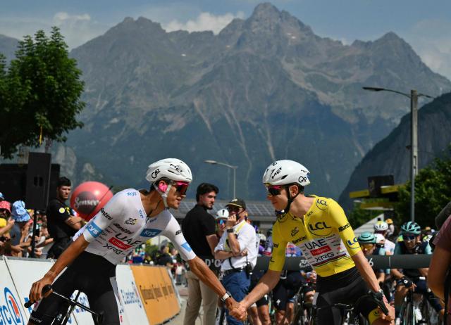 UAE Team Emirates - XRG's Slovenian rider Tadej Pogacar wearing the overall leader's yellow jersey shakes hands with UAE Team Emirates - XRG's Mexican rider Isaac Del Toro at the start of the 20th stage of the 113th edition of the Tour de France cycling race, 170,9 km between Le Bourg-d'Oisans and Alpe d'Huez in the French Alps, on July 25, 2026. (Photo by Jeff PACHOUD / AFP)