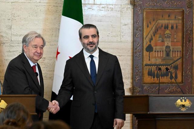 UN Secretary-General Antonio Guterres (L) and Syria's Foreign Affairs Minister Asaad al-Shaibani shake hands during a joint press conference following their meeting at the Tishreen Palace in the Syrian capital Damascus on July 25, 2026. United Nations Secretary-General Antonio Guterres urged international support for Syria on July 25, as he visited the country, which is in transition following years of war and the overthrow of longtime ruler Bashar al-Assad. Guterres is the first UN chief to visit Syria since his predecessor Ban Ki-moon in 2009, two years before the start of Syria's civil war which went on to kill more than half a million people before the new Islamist authorities took power in December 2024. (Photo by LOUAI BESHARA / AFP)