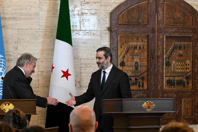 UN Secretary-General Antonio Guterres (L) and Syria's Foreign Affairs Minister Asaad al-Shaibani shake hands during a joint press conference following their meeting at the Tishreen Palace in the Syrian capital Damascus on July 25, 2026. United Nations Secretary-General Antonio Guterres urged international support for Syria on July 25, as he visited the country, which is in transition following years of war and the overthrow of longtime ruler Bashar al-Assad. Guterres is the first UN chief to visit Syria since his predecessor Ban Ki-moon in 2009, two years before the start of Syria's civil war which went on to kill more than half a million people before the new Islamist authorities took power in December 2024. (Photo by LOUAI BESHARA / AFP)