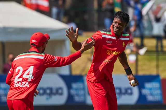 TOPSHOT - Zimbabwe captain Sikandar Raza (L) celebrates the wicket of Vaibhav Sooryavanshi (unseen) with Blessing Muzarabani during of the second Twenty20 international cricket match between Zimbabwe and India at Harare Sports Club in Harare, on July 25, 2026. (Photo by Jekesai NJIKIZANA / AFP)