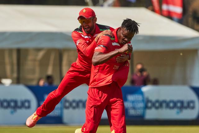 TOPSHOT - Zimbabwe captain Sikandar Raza (L) celebrates the wicket of Vaibhav Sooryavanshi (unseen) with Blessing Muzarabani during of the second Twenty20 international cricket match between Zimbabwe and India at Harare Sports Club in Harare, on July 25, 2026. (Photo by Jekesai NJIKIZANA / AFP)