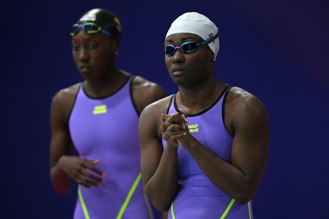 Ghana's Nubia Adjei (R) and Unitez Takyi prepare to swim in the Mixed 4x100m Freestyle Relay heats during the swimming event at the Tollcross International Swimming Centre in Glasgow, on day two of the Commonwealth Games in Glasgow, Scotland, on July 25, 2026. (Photo by Oli SCARFF / AFP)