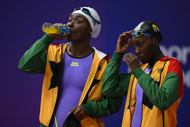 Ghana's Nubia Adjei (R) and Unitez Takyi prepare to swim in the Mixed 4x100m Freestyle Relay heats during the swimming event at the Tollcross International Swimming Centre in Glasgow, on day two of the Commonwealth Games in Glasgow, Scotland, on July 25, 2026. (Photo by Oli SCARFF / AFP)