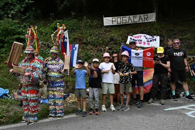 Spectators line the race route cycles in the Col du Telegraphe ascent during the 20th stage of the 113th edition of the Tour de France cycling race, 170,9 km between Le Bourg-d'Oisans and Alpe d'Huez in the French Alps, on July 25, 2026. (Photo by Loic VENANCE / AFP)