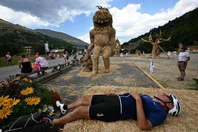 A spectator naps cheer along the race route in the Col du Telegraphe ascent during the 20th stage of the 113th edition of the Tour de France cycling race, 170,9 km between Le Bourg-d'Oisans and Alpe d'Huez in the French Alps, on July 25, 2026. (Photo by Loic VENANCE / AFP)