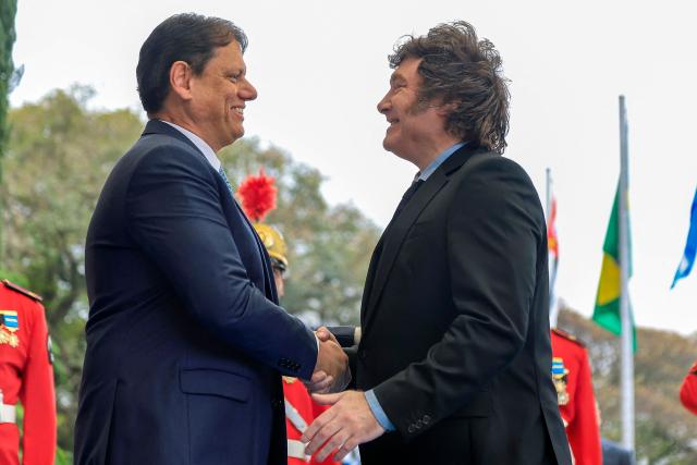Argentina's President Javier Milei (R) shakes hands with Sao Paulo's governor Tarcisio de Freitas on arrival at the Bandeirantes Palace, in Sao Paulo, Brazil on July 25, 2026. Milei is visiting Brazil to meet with right-wing presidential hopeful Flavio Bolsonaro and take part in the Liberal Party convention that supports his candidacy, (Photo by Miguel SCHINCARIOL / AFP)