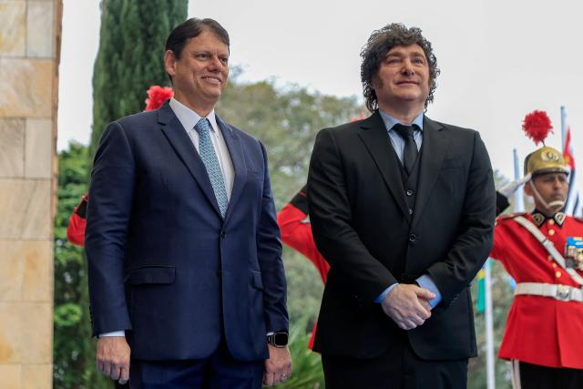 Argentina's President Javier Milei (R) and Sao Paulo's governor Tarcisio de Freitas stand in front of a guard of honour at the Bandeirantes Palace, in Sao Paulo, Brazil on July 25, 2026. Milei is visiting Brazil to meet with right-wing presidential hopeful Flavio Bolsonaro and take part in the Liberal Party convention that supports his candidacy, (Photo by Miguel SCHINCARIOL / AFP)
