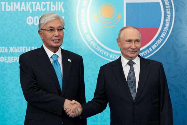 In this pool photograph distributed by the Russian state agency Sputnik, Russia's President Vladimir Putin (R) greets Kazakhstan's President Kassym-Jomart Tokayev during the 22nd Russia-Kazakhstan Forum of Interregional Cooperation in Omsk on July 25, 2026. (Photo by Vyacheslav PROKOFYEV / POOL / AFP)