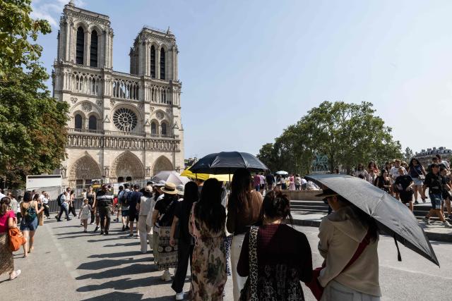 Tourists visit the Trocadéro with the Eiffel Tower seen in the background in Paris on July 25, 2026. (Photo by Xavier GALIANA / AFP)