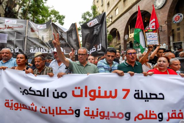 People gather to protest Tunisia's President Kais Saied during a demonstration marking five years since his suspension of parliament and assumption of emergency powers, in Tunis on July 25, 2026. (Photo by FETHI BELAID / AFP)