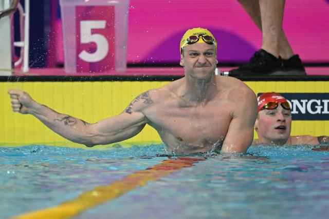 Australia's Sam Williamson reacts after winning the Men's 100m Breaststroke Final during the swimming event at the Tollcross International Swimming Centre in Glasgow, on day two of the Commonwealth Games in Glasgow, Scotland, on July 25, 2026. England's Adam Ramsay-Peaty (R) finsihed third. (Photo by Oli SCARFF / AFP)