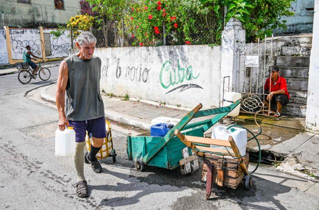 A cuban carries potable water in Pinar del Rio, Cuba, on July 25, 2026, on the eve of the 73rd anniversary of the guerrilla assault on the Moncada Barracks, considered the start of the Cuban Revolution. (Photo by YAMIL LAGE / AFP)