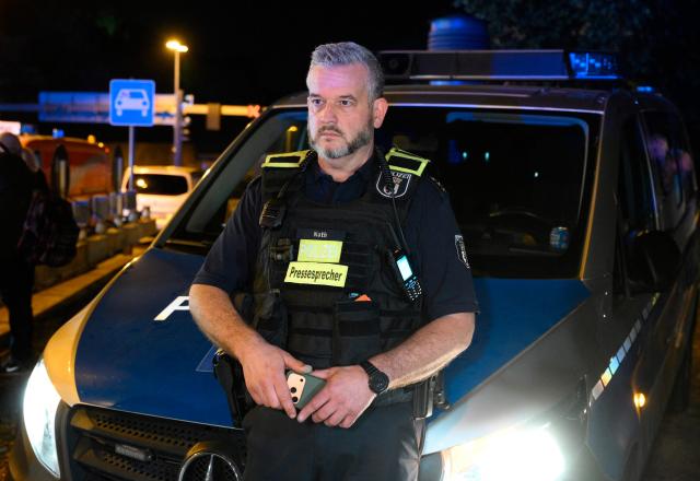 Police spokesman Florian Nath looks on near the scene where one person was killed and around 15 injured after a car is believed to have hit the crowd on the outskirts of the Christopher Street Day (CSD) parade in Berlin, on July 25, 2026. "We believe that a vehicle entered the Tiergarten park and hit several people and injured them," police posted on social media. The injured were being treated by the emergency services and they were actively seeking the people responsible, they added. (Photo by RALF HIRSCHBERGER / AFP)