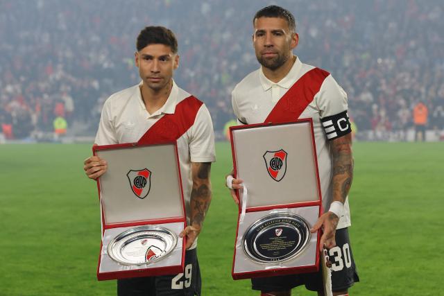 River Plate's defenders #29 Gonzalo Montiel (L) and #30 Nicolas Otamendi pose with a plate commemorating their participation at the FIFA 2026 World Cup ahead of the Argentine Professional League 2026 Clausura football match between River Plate and Barracas Central at MAS Monumental Stadium in Buenos Aires on July 25, 2026. (Photo by Alejandro PAGNI / AFP)