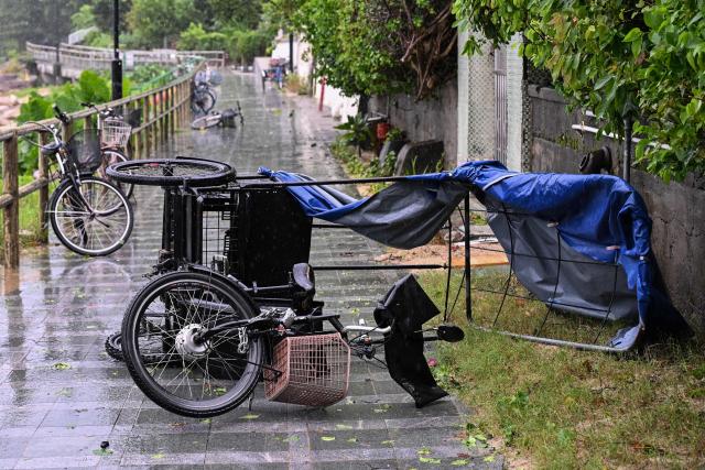 A trike is seen overturned on a beach path by strong winds from Typhoon Noul which passed close to Hong Kong on July 26, 2026. (Photo by Peter PARKS / AFP)