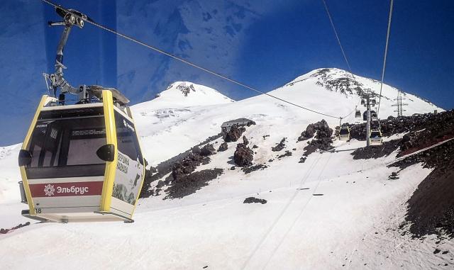 This file photograph taken on June 6, 2022 shows a cable car running above the slopes of Mount Elbrus near Terskol, Russia's Kabardino-Balkarian Republic. Two Bosnian mountaineers have died on Mount Elbrus in Russia's Caucasus, and the search is continuing for three other people who remain missing, the state news agency TASS and the regional prosecutor said on July 26, 2026. (Photo by Alexander NEMENOV / AFP)