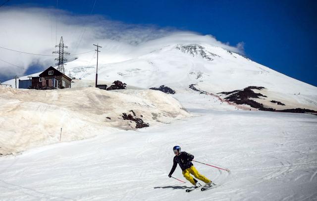 In this file photograph taken on June 6, 2022, a skier descends the slopes of Mount Elbrus near Terskol, Russia's Kabardino-Balkarian Republic. Two Bosnian mountaineers have died on Mount Elbrus in Russia's Caucasus, and the search is continuing for three other people who remain missing, the state news agency TASS and the regional prosecutor said on July 26, 2026. (Photo by Alexander NEMENOV / AFP)