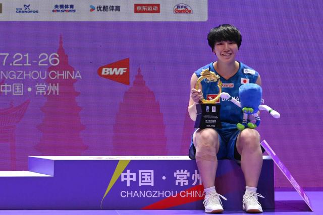 Japan's Akane Yamaguchi poses on the podium after defeating China's Chen Yufei in the women's singles final at the China Open badminton tournament in Changzhou, in eastern China's Jiangsu province on July 26, 2026. (Photo by CN-STR / AFP) / China OUT