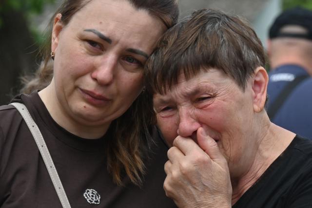 EDITORS NOTE: Graphic content / Residents mourn following an air attack in Kharkiv on July 26, 2026, amid the Russian invasion of Ukraine. (Photo by SERGEY BOBOK / AFP)