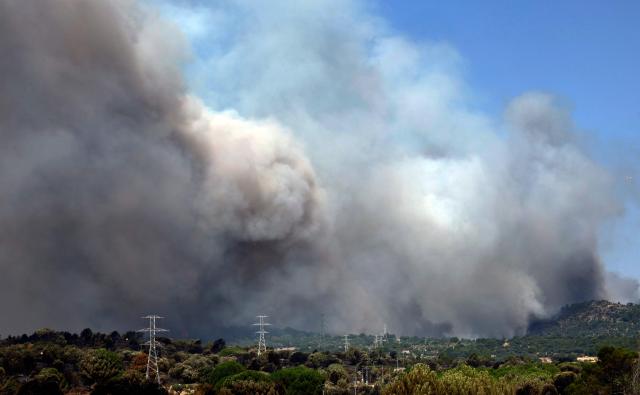 Thick smoke billows rise over the landscape near Pelayos de la presa, 65 kilometers west of Madrid, during a wildfire raging in the region on July 26, 2026. Spanish firefighters today battled a new front of fires near the coastal city of Valencia, where at least 15,000 people were evacuated. In the western Madrid region, two separate wildfires merged on July 24 into a massive blaze that nearly joined another fire in neighboring Castile and Leon. The flames have already burned 25,000 hectares across Madrid and neighboring Avila province, forcing more than 60,000 people (a downwardly revised figure) to flee their homes, according to authorities, who labeled the fire the "worst in history" for the Madrid region. (Photo by Oscar DEL POZO / AFP)
