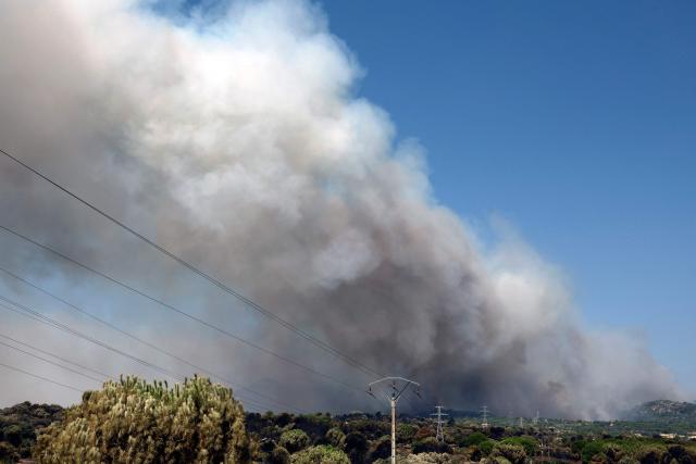 Thick smoke billows rise over the landscape near Pelayos de la presa, 65 kilometers west of Madrid, during a wildfire raging in the region on July 26, 2026. Spanish firefighters today battled a new front of fires near the coastal city of Valencia, where at least 15,000 people were evacuated. In the western Madrid region, two separate wildfires merged on July 24 into a massive blaze that nearly joined another fire in neighboring Castile and Leon. The flames have already burned 25,000 hectares across Madrid and neighboring Avila province, forcing more than 60,000 people (a downwardly revised figure) to flee their homes, according to authorities, who labeled the fire the "worst in history" for the Madrid region. (Photo by Oscar DEL POZO / AFP)