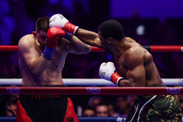 Britain's Anthony Joshua (R) and Albania's Kristian Prenga trade blows during their heavyweight boxing fight at the Jeddah Superdome in Jeddah on July 26, 2026. Two-time heavyweight world champion Anthony Joshua survived two early knockdowns on the way to a second-round knockout of Kristian Prenga on July 26, his triumphant ring return paving the way for a blockbuster all-British bout with Tyson Fury. (Photo by AFP)