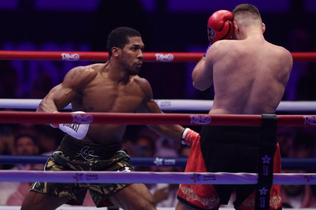 Britain's Anthony Joshua (L) and Albania's Kristian Prenga trade blows during their heavyweight boxing fight at the Jeddah Superdome in Jeddah on July 26, 2026. Two-time heavyweight world champion Anthony Joshua survived two early knockdowns on the way to a second-round knockout of Kristian Prenga on July 26, his triumphant ring return paving the way for a blockbuster all-British bout with Tyson Fury. (Photo by AFP)